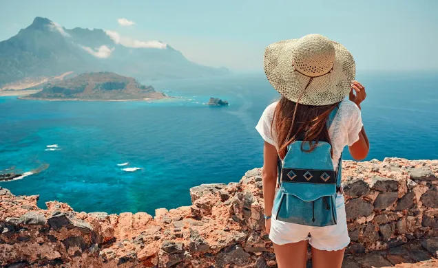 vue ensoleillée du bord de mer avec une femme portant un chapeau tressé